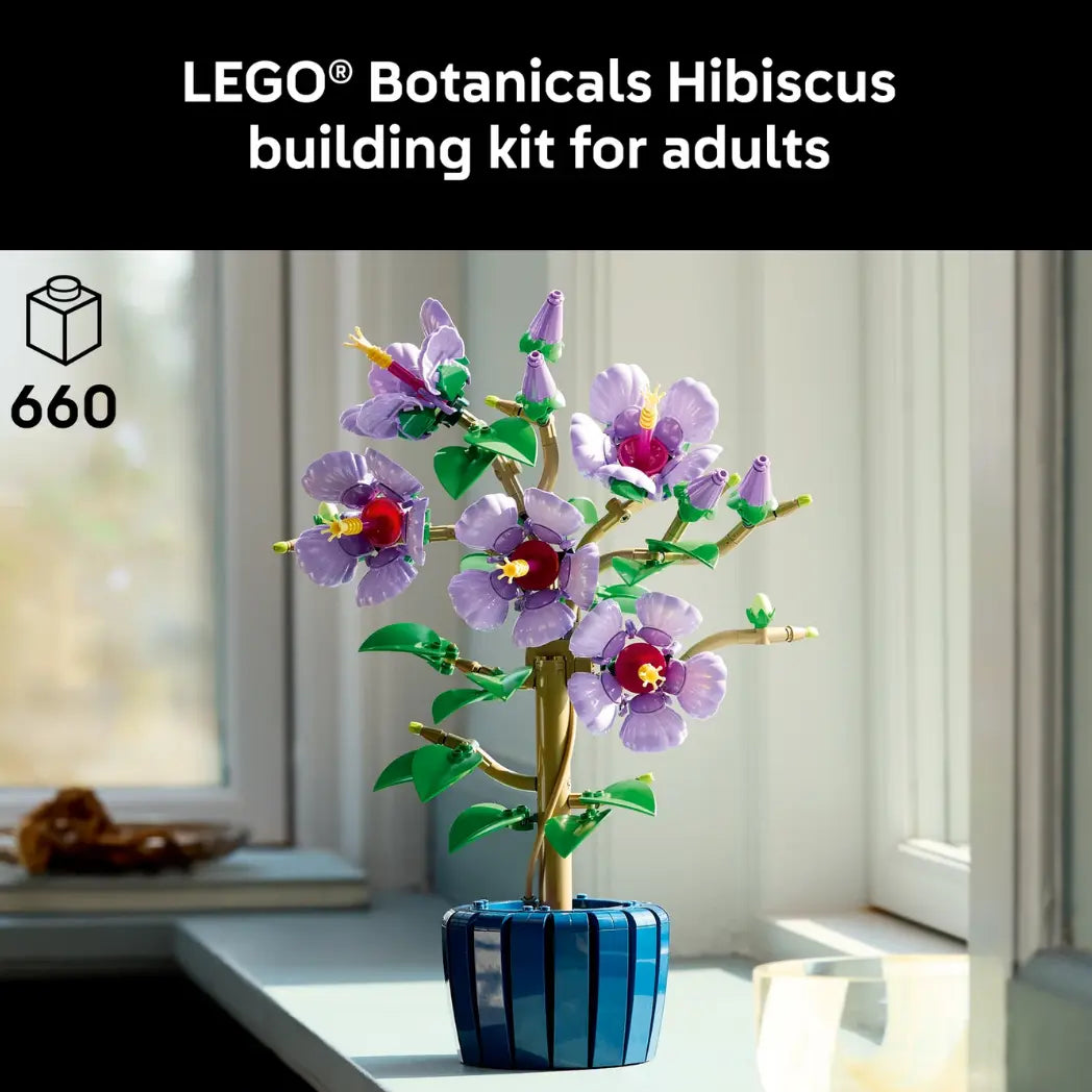LEGO Hibiscus Flower model in a blue pot displayed on a windowsill with a black text banner above saying lego botanicals hibiscus building kit for adults.