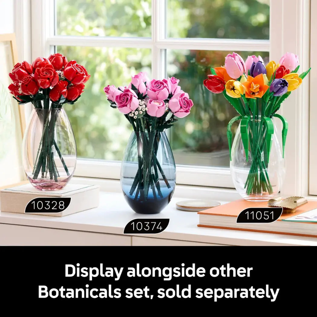 Three LEGO Botanical bouquets. red roses, pink roses, and colorful tulips, displayed in glass vases on a windowsill with set numbers 10328, 10374, and 11051.