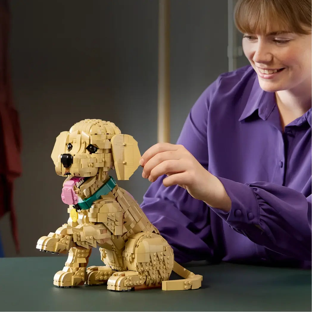 LEGO Golden Retriever Puppy figure being adjusted by a woman in a purple shirt to show its poseable features.