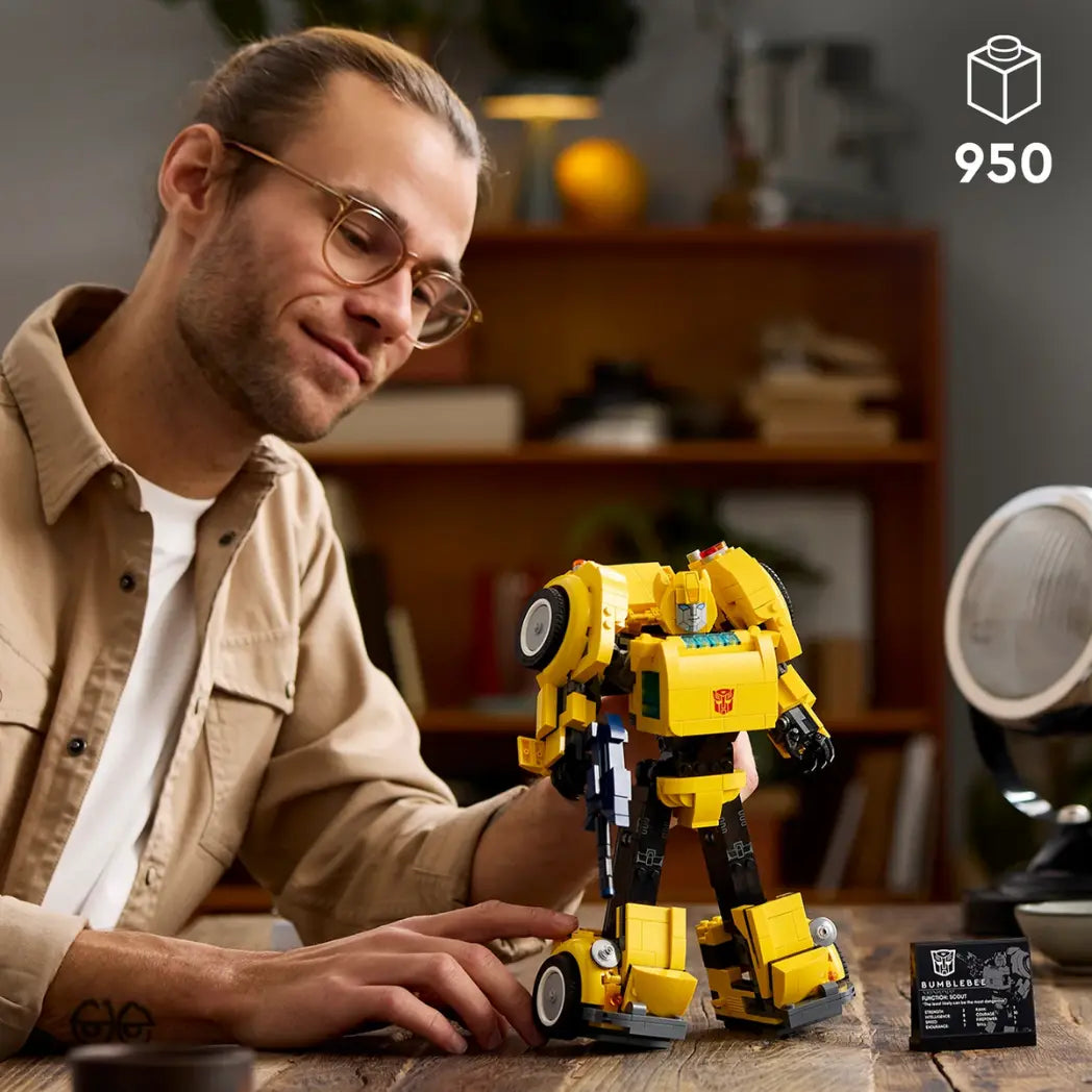 LEGO Transformers Bumblebee figure standing in robot mode on a wooden table next to its character display plaque with a guy posing it.