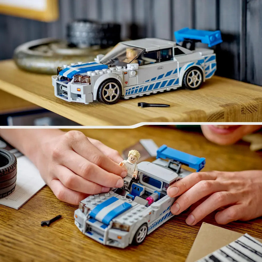 LEGO Nissan Skyline GT-R (R34) car with Brian O'Conner minifigure standing next to the silver and blue vehicle.